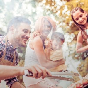 Happy family having a barbecue in their garden in summer.Leisure, food, family and holidays concept.